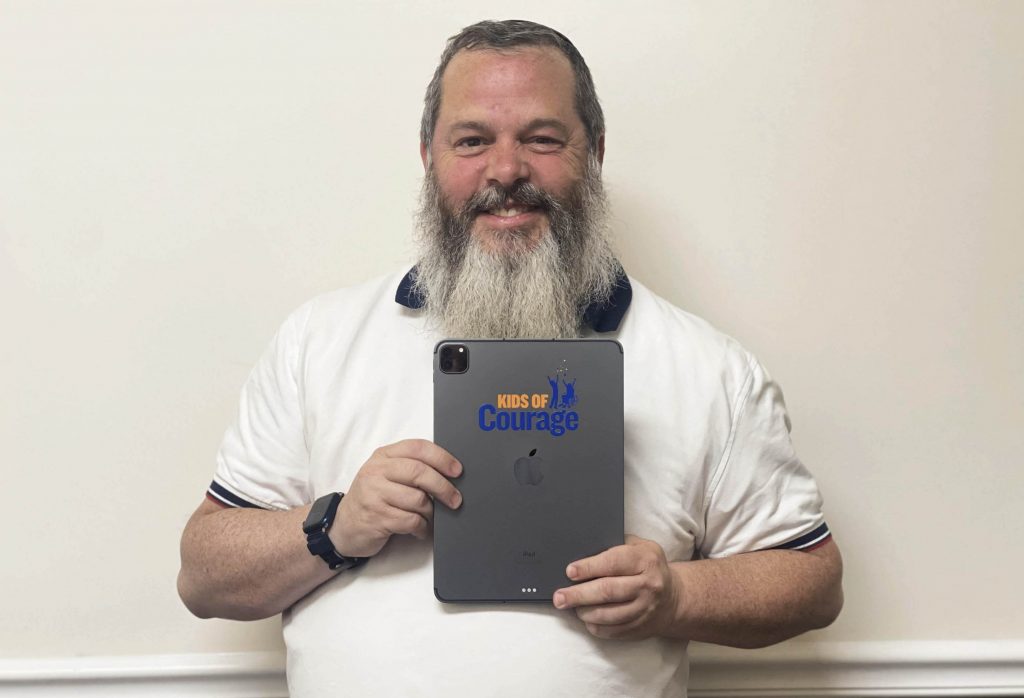 Naftali Solomon, director of operations at Kids of Courage, shows off a custom branded Apple iPad used to help spread awareness of the organization.